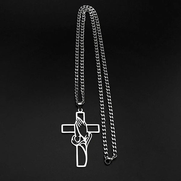 Silver chain necklace with a cross pendant on a black background