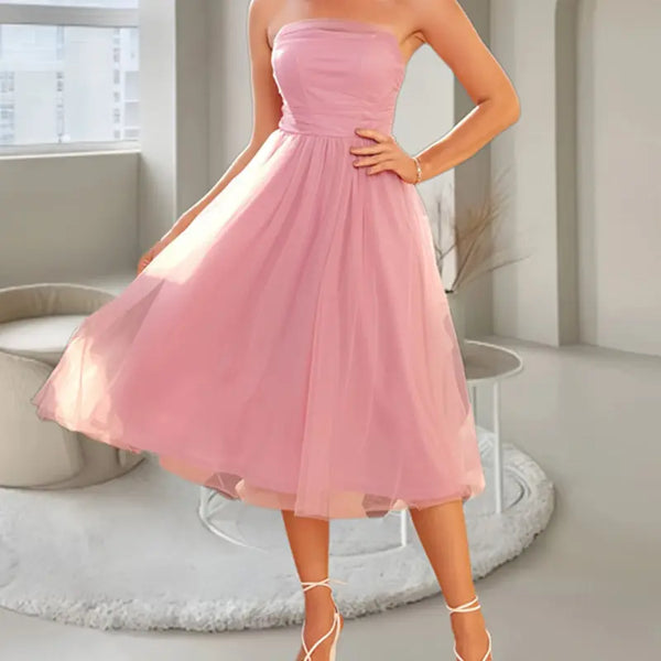 Pink strapless dress worn by a person in a minimalistic room.