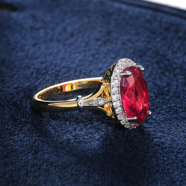 Gold ring with a red gemstone on a dark blue textured background