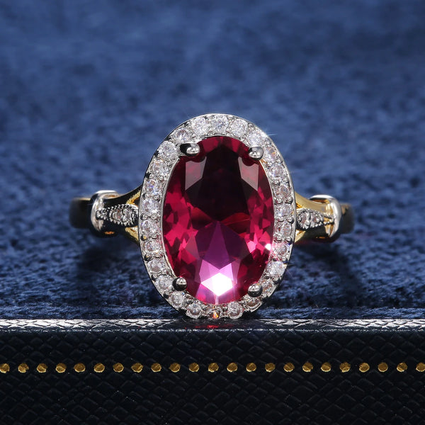 Ring with a red gemstone and diamond accents on a textured blue and black background