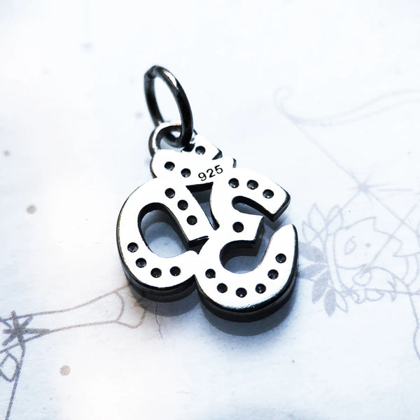Silver pendant with '925' stamp on a light background