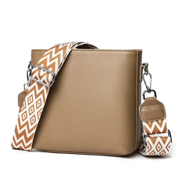 Beige handbag with a patterned strap on a white background