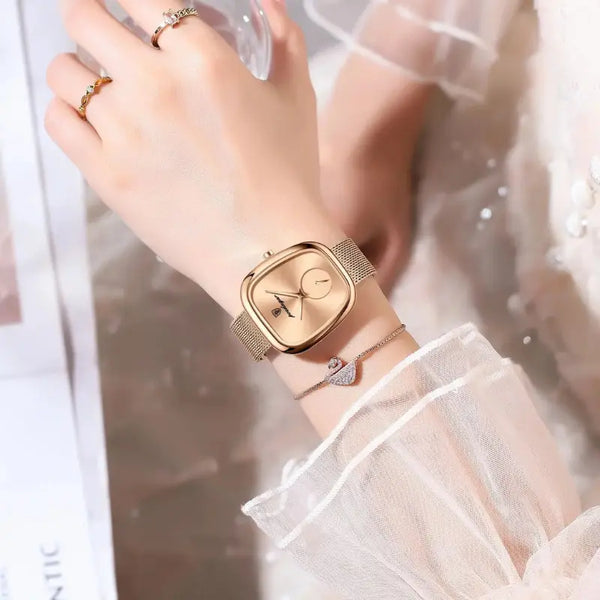Gold wristwatch on a wrist with a blurred background