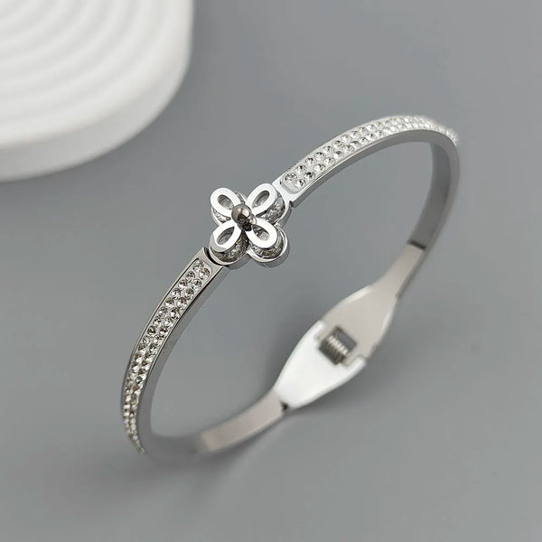 Silver bracelet with a floral design on a gray background