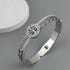 Silver bracelet with intricate design on a gray background