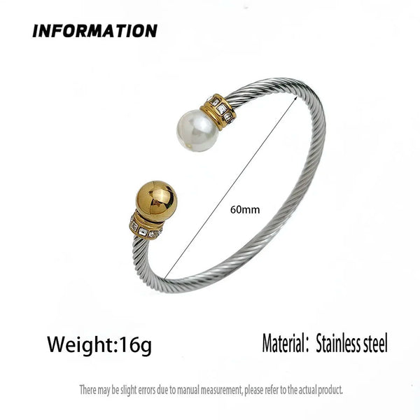 Silver stainless steel cable bangle bracelet with a white pearl and gold-toned bezel details, shown with a 60mm dimension line and text specifying weight and material on a white background.